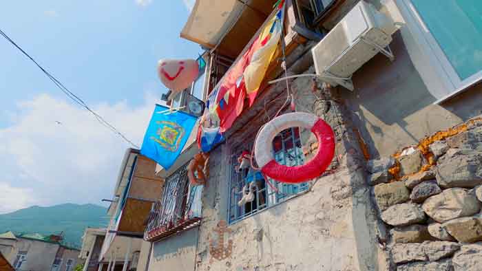 Жилой дом, разукрашенный флагами, спасительным кругом и различными безделушками