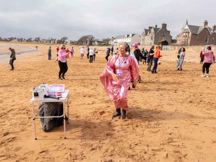 Silent disco. People dancing with headphones to music on the beach in Elie, Scotland.