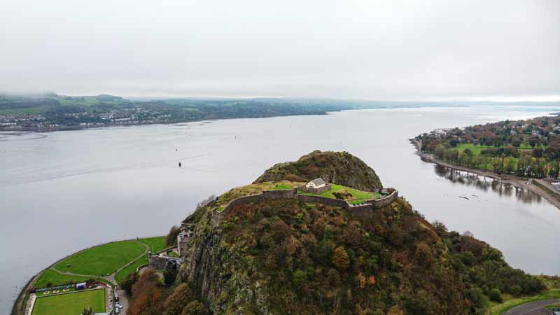 Аэрофотосъемка замка-крепости Дамбартон на скале Дамбартон-Рок на фоне широкой панорамы реки Клайд