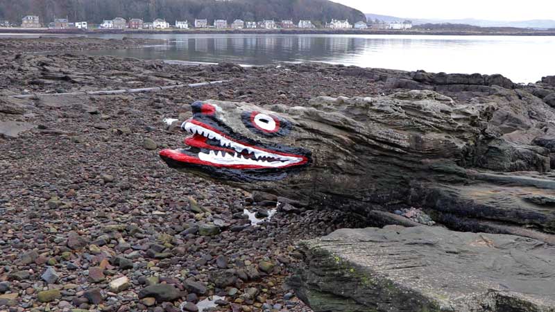 Панорамный вид на пляж с камнем Crocodile Rock в Миллпорте.