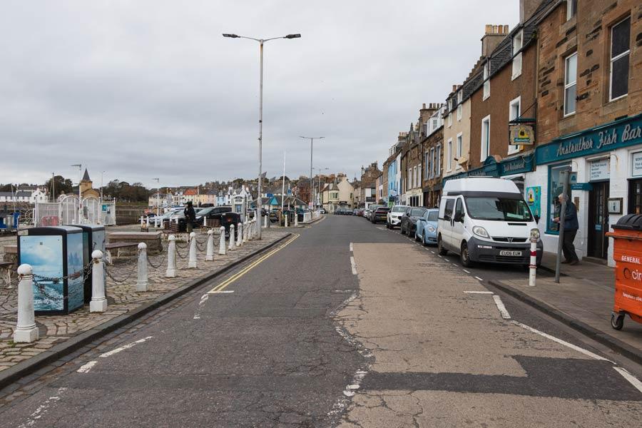 Улица с припаркованными машинами, фургоном и вывеской Anstruther Fish Bar в Анструтере